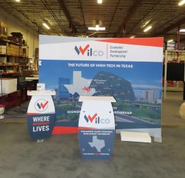 SYK-1014 Symphony Portable Display w/ SEG Fabric Graphic, (2) Backwall Workstations, Wireless Charging Pads, Monitor Mount, LED Stem Lights, and an SYM-408 Reception Counter with Locking Storage