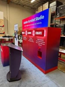 Custom Exhibit with LED Halo and Backlit Lights, SuperNova Header Lightbox, Lighting Remote, SYM-416 Counter with Fabric Graphics, and MOD-1549 Lectern with Graphics -- View 3