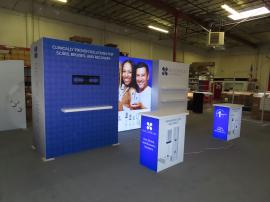 Gravitee Modular Inline Exhibit with Tension Fabric Graphics, SuperNova Lightbox, Shelves, Monitor Mount, Closet Storage, and (2) MOD-1703 Reception Counters