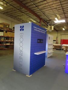 Gravitee Modular Inline Exhibit with Tension Fabric Graphics, SuperNova Lightbox, Shelves, Monitor Mount, Closet Storage, and (2) MOD-1703 Reception Counters -- View 3