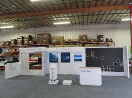 Custom Reconfigurable Inline Exhibit with Full-size Closet, Backlit Logos, Lightboxes, Reception Counter with LED Accent Lights, Riser, Product Display, and Opening for LED Video Tiles -- View 3