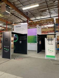 RENTAL: Modified RE-9211 Gravitee Island Design with Conference Room at 118' Wide x 118' Deep x 142.5' High, (2) Gravitee Arch Canopies, (2) Large Monitor Mounts, RE-1229 Large Monitor Stand, White Unprinted Sintra Insert Panels, Direct Print Sintra Infil